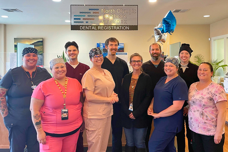 NOHN Family Dentistry staff posing for a photo with sign and balloons in background.