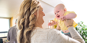 Woman holding a smiling baby up to her face